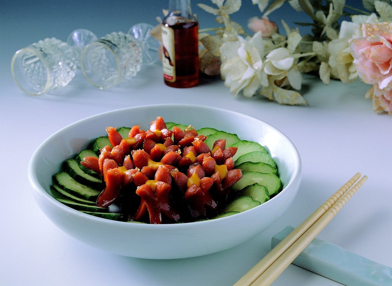 Vibrant salad bowl featuring sausages and cucumber slices, perfect for a nutritious meal.